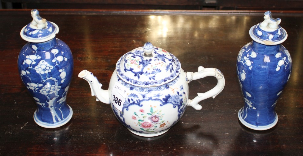 An 18th century Chinese export teapot and a pair of prunus pattern vases and covers